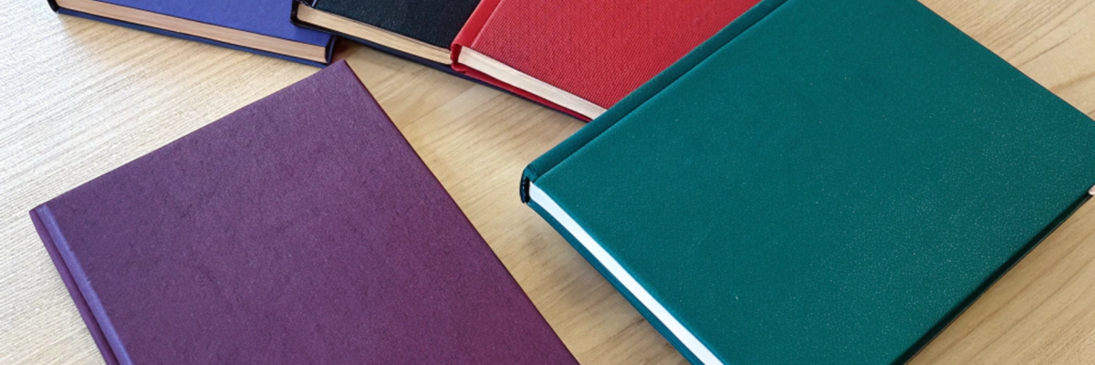 Top view of several thin university thesis books w